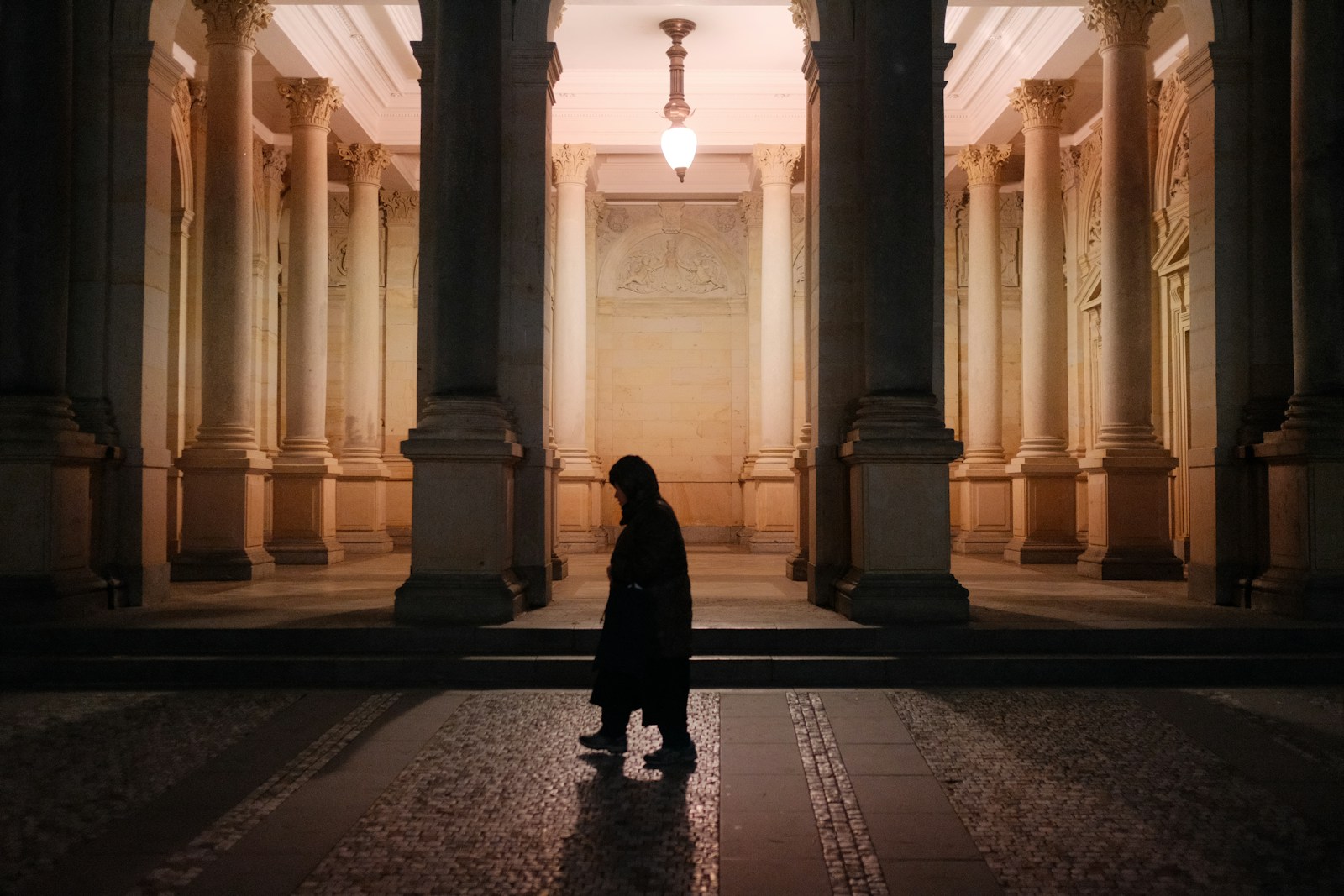 A person standing in front of a building with columns